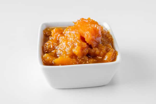 A close-up of a white bowl filled with sweet potato casserole