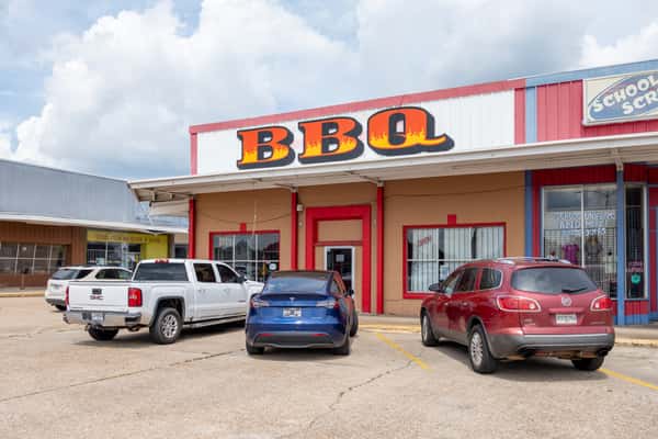 The exterior of Smoke T's BBQ restaurant building with signage and parking lot