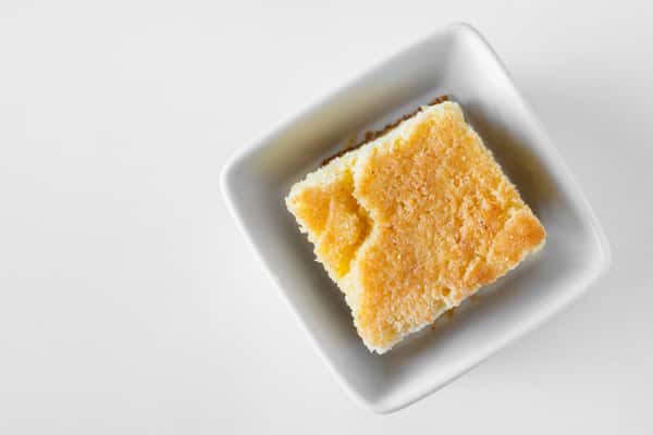 A golden square of cornbread in a baking dish viewed from above