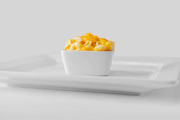 A white bowl filled with creamy mac and cheese viewed straight on