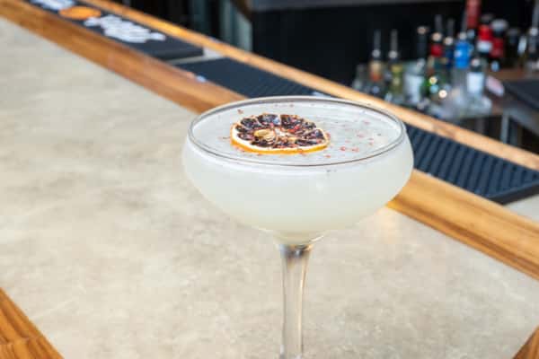 Pink Cadilac cocktail topped with a citrus garnish