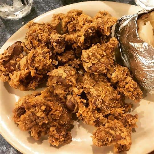 plate on a table with fried chicken.