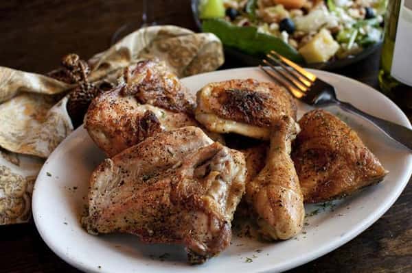 Grilled chicken breasts and drumsticks on a plate.