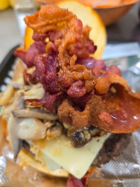 John Hoover Inn gourmet burger topped with crispy bacon, sautéed mushrooms, and yellow cheese.
