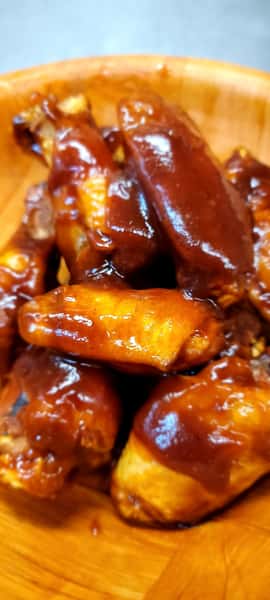 The John Hoover Inn's sticky, glossy BBQ chicken wings served piled high in a warm wooden bowl.