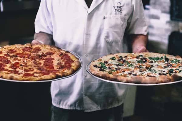 chef holding pizzas