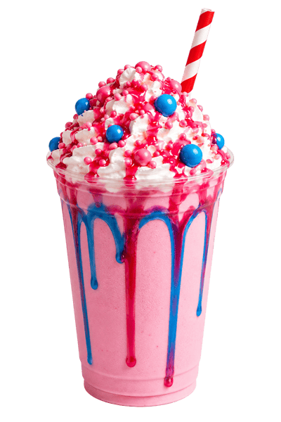 Pink dessert milkshake topped with whipped cream, candy pearls, colorful chocolate candies, and sweet syrup drizzle