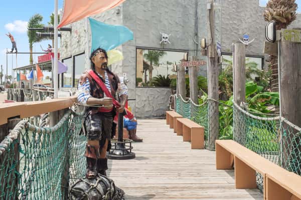 boardwalk leading into the restaurant with a Pirate statue