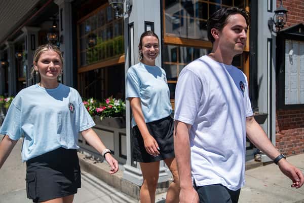 group of young people walking on street with red parrot shirts