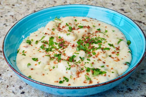 Creamy gnocchi in white sauce topped with herbs and crispy bits
