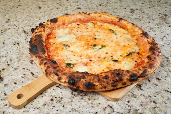 classic Neapolitan Margherita pizza with fresh basil on wooden peel