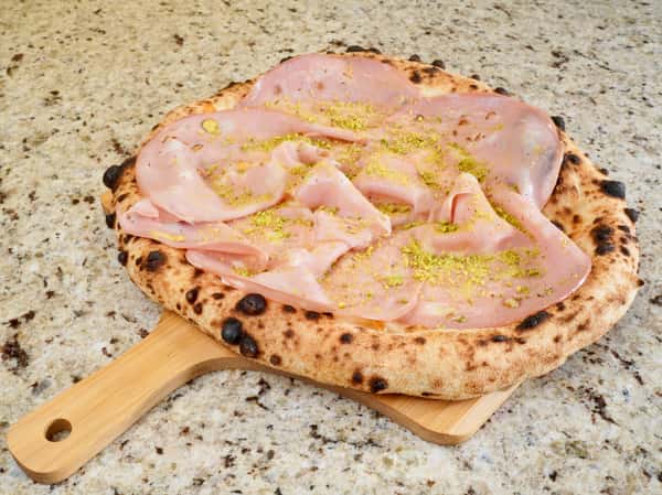 Neapolitan pizza topped with mortadella slices and crushed pistachios