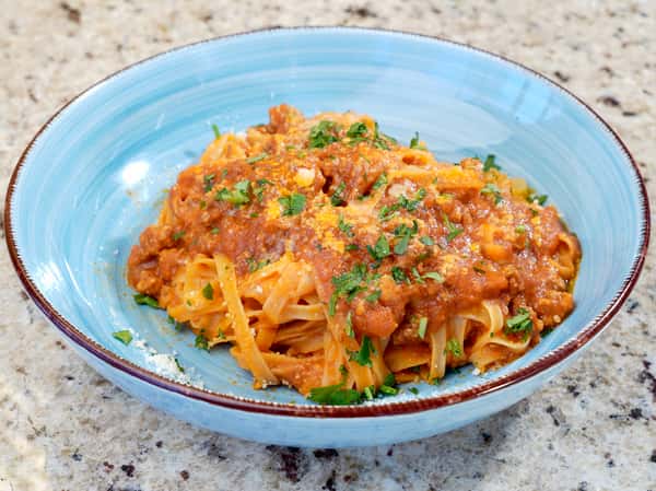 Tagliatelle pasta with meat ragù and grated cheese