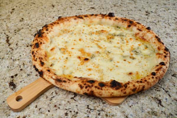four cheese pizza on wooden peel over marble background