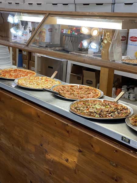 a variety of specialty pizzas on a table