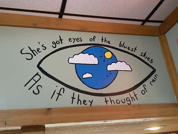 a sign in the restaurant that says "she's got eyes of the bluest skies as if they thought of rain"