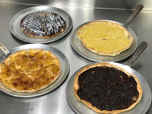 2 chocolate pizzas, a vanilla pizza, and an apple pizza on a table