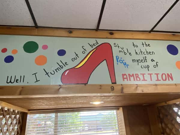 a sign in the restaurant that says "well, i tumble out of bed, stumble to the kitchen, pour myself a cup of ambition"