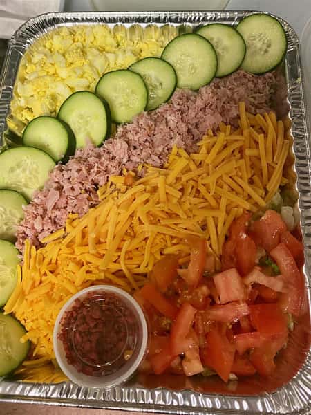 eggs, cucumbers, ham, cheese, and tomatoes in a tray