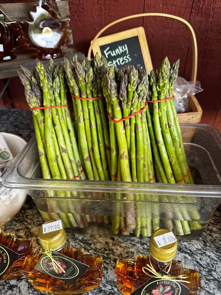 Fresh green asparagus bundles are neatly arranged at the market stand, highlighting crisp seasonal produce and farm-fresh quality.