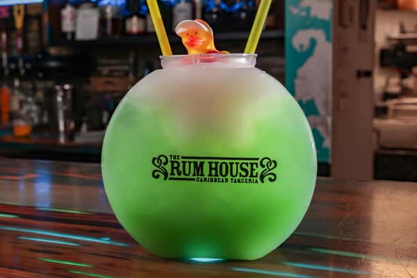 Frozen cocktail served in a large glass with a lifeguard rubber duck and two yellow straws.