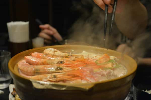 Steam rising from a seafood hot pot with shrimp at Sumiya