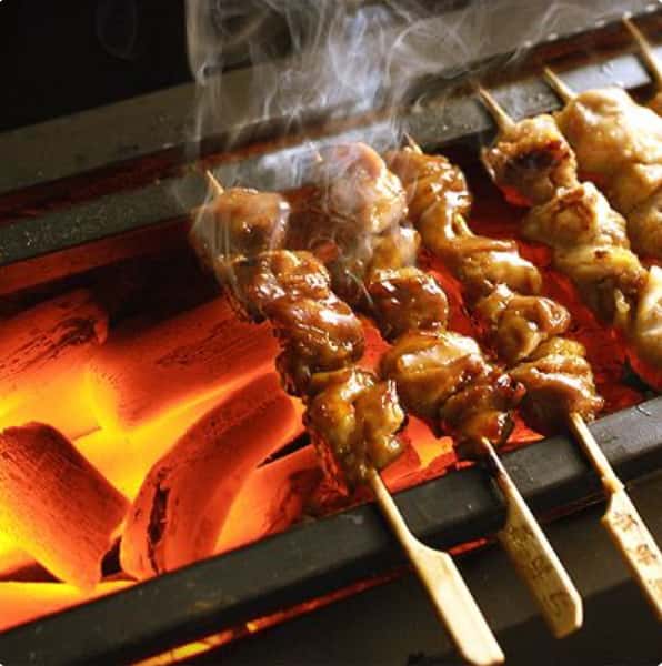 Skewers of meat and vegetables grilling over an open flame