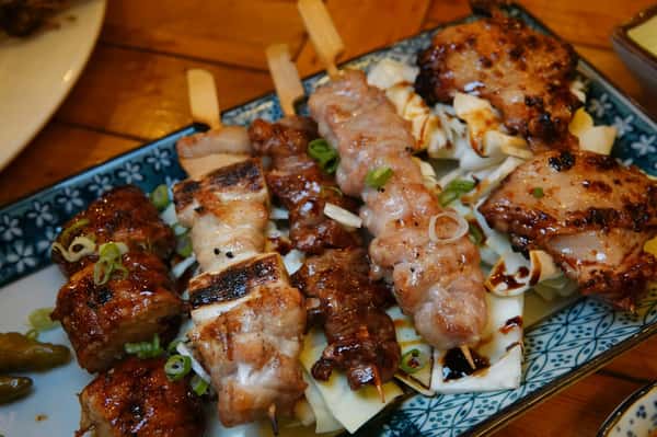 Grilled yakitori skewers topped with sesame seeds, served as part of Sumiya's signature Japanese cuisine
