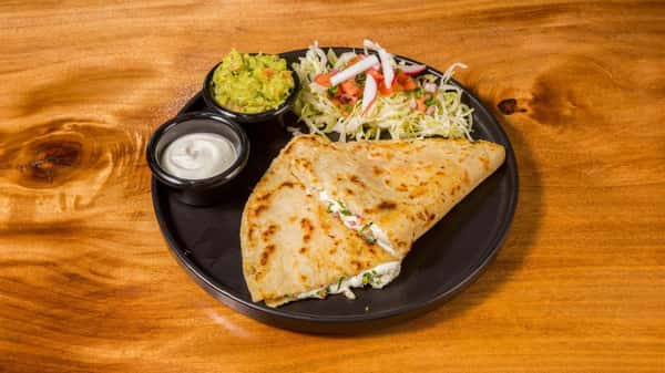 Chicken quesadilla served with guacamole and fresh slaw.