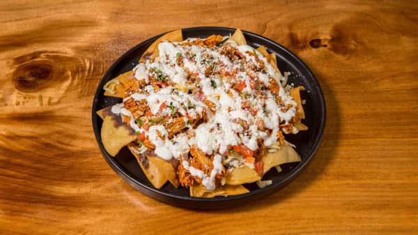 Loaded nachos topped with seasoned meat, cheese, sour cream, and pico de gallo.