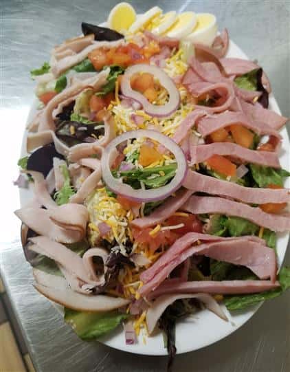 chef salad topped with cold cuts and cheese