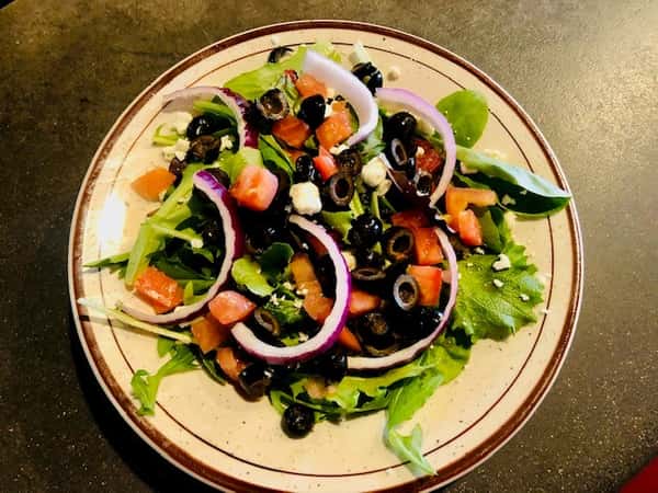 Greek Salad: Acadia blend lettuce topped with feta cheese, tomatoes, red onions, black olives and Greek dressing. Served with warm flat bread