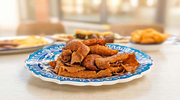 Thinly sliced kebab meat on a blue and white patterned plate.