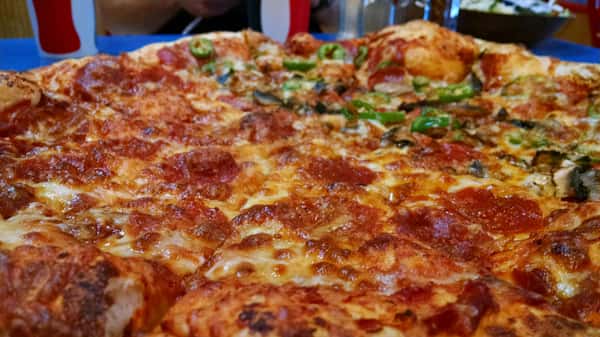 Close-up of a large half pepperoni and half veggie pizza topped with jalapeños, mushrooms, and green peppers — a perfect blend of spicy and savory flavors ideal for casual dining and pizza chains.