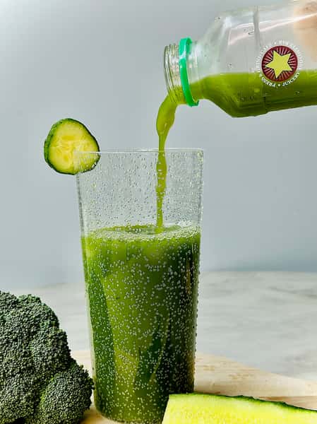 Pouring green juice in a cup