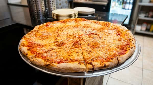 Large cheese pizza with tomato sauce, mozzarella, and a thick crust, sliced into wedges, on a metal tray.