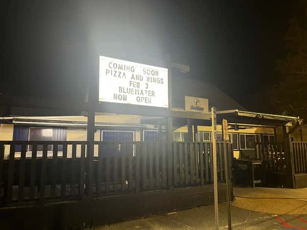 outside of the restaurant with a sign