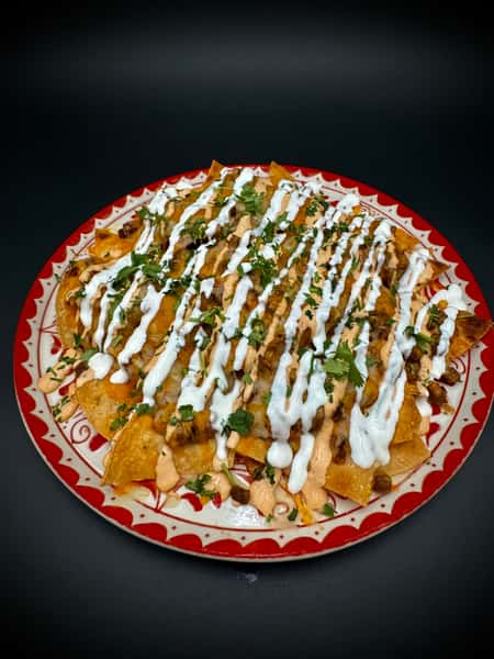 Nchos filled with steak, chipotle, sour cream, beans, and cilantro.