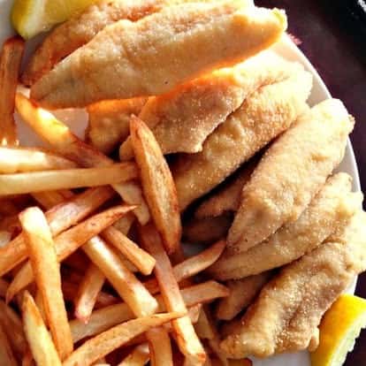 Golden fried fish fillets paired with crispy French fries and lemon wedges—classic fish and chips plate served hot and fresh.