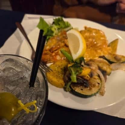 Creamy seafood dish served with grilled squash, zucchini, and onions, topped with a lemon wedge—flavorful surf and turf combination with a healthy twist.