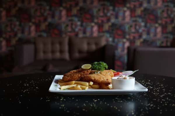 Crispy fish and chips served with garnish and dip