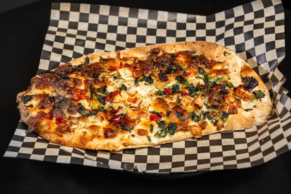 Top down view of Supreme Flatbread on checkered paper