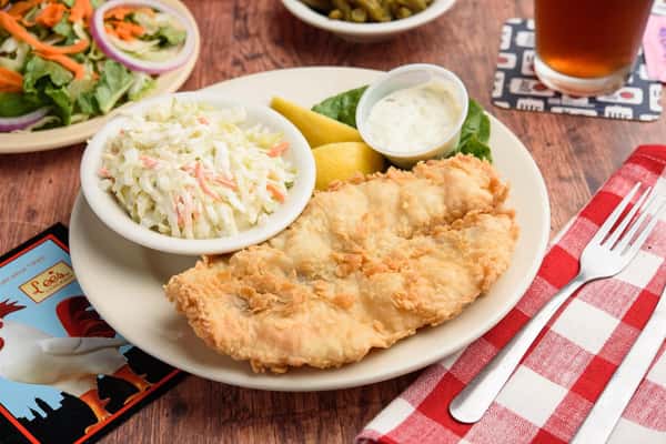 fried fish with a side of coleslaw and lemons