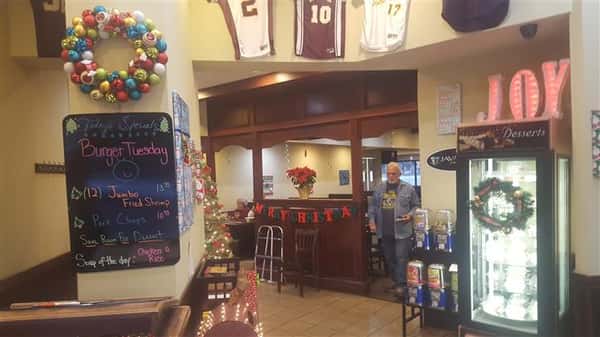 Entrance of dining area with Christmas decorations up with man walking through.