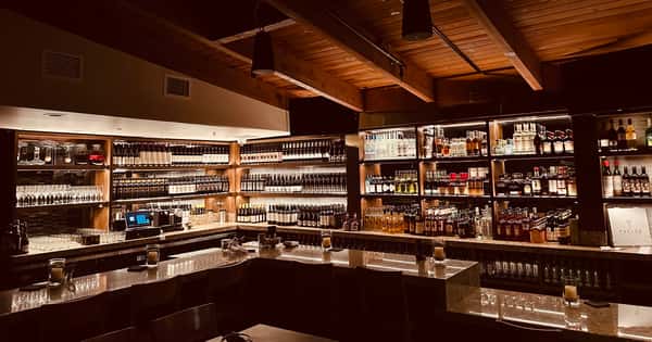 The stylish bar at Parlor San Clemente, featuring a wide selection of craft cocktails, local beers, and an inviting atmosphere perfect for socializing and enjoying a drink.