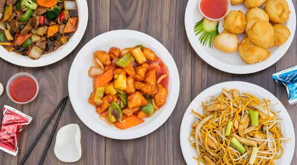Assortment of Chinese dishes, including sweet and sour chicken, lo mein, beef with vegetables, and fried dumplings.