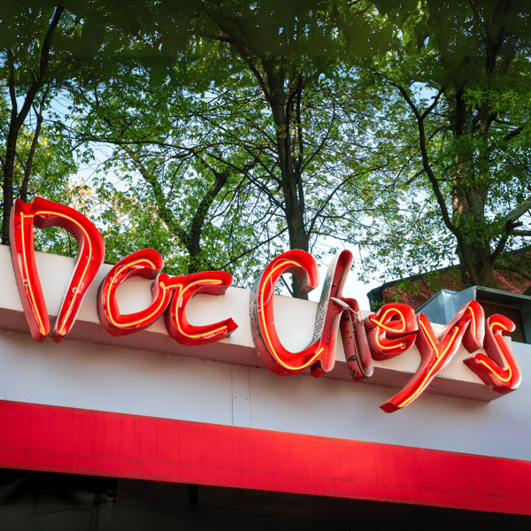 Neon Sign hanging on the front of Doc Chey's building