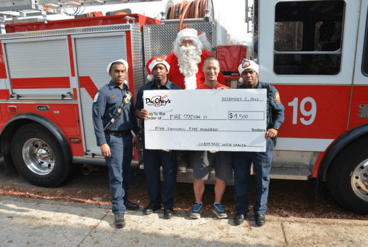 Rich Chey and Virginia Highland Fire Station 19 firefighters holding up a giant check from Doc Chey's Fundraiser