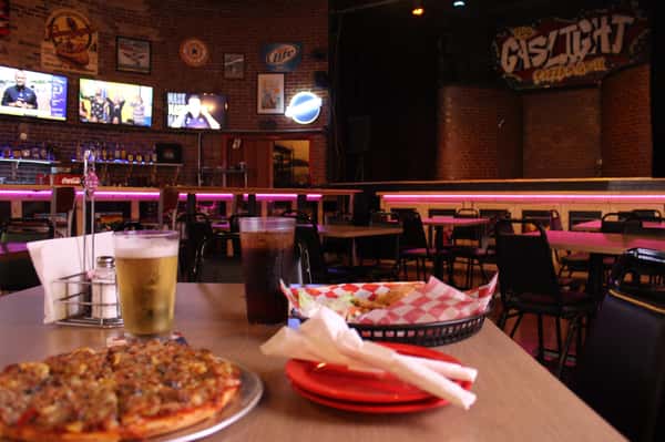 pizza pie with cola and beer in front of stage