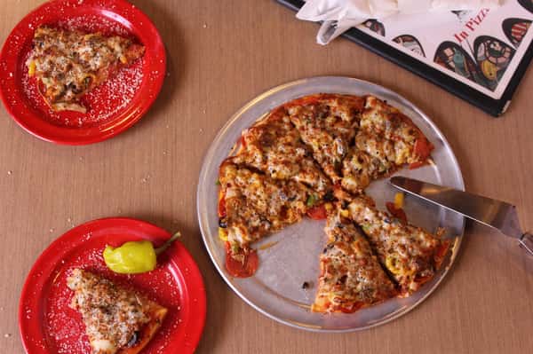 pizza pie with slices on plates